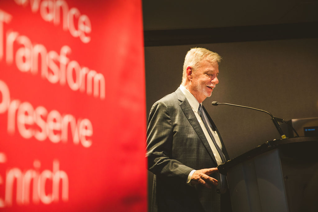 A photo of Larry Alford delivering a speech during the Ron MacDonald Award Ceremony.