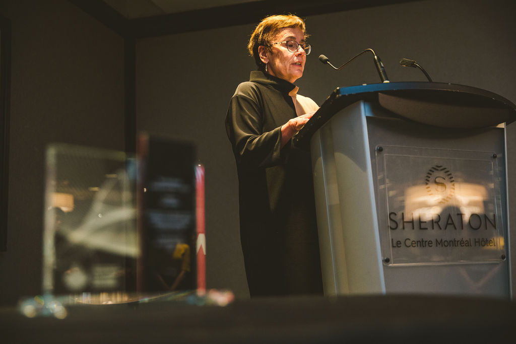 A photo of Annette Trimbee delivering a speech during the Ron MacDonald Award Ceremony.