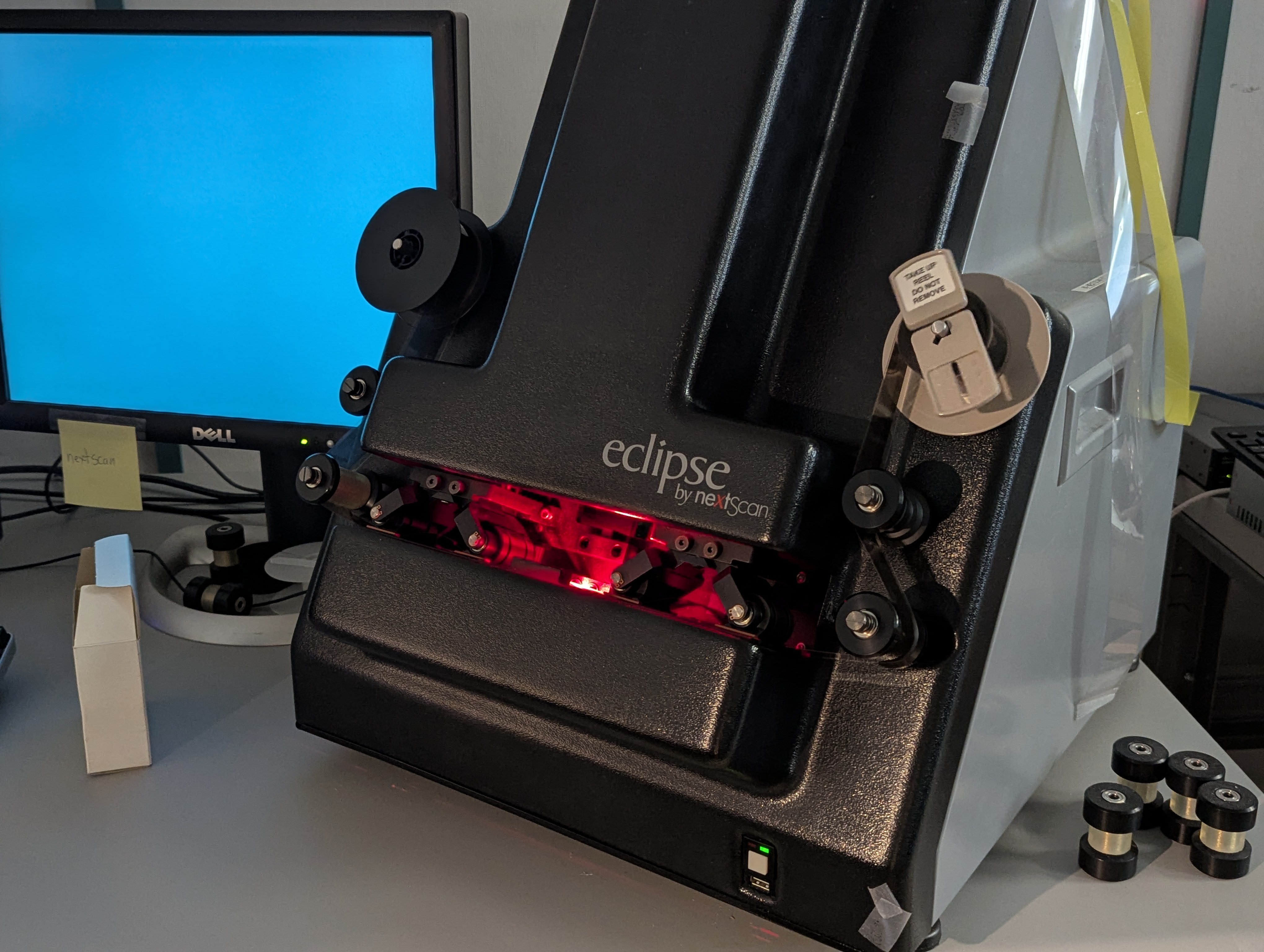 Un scanner de microfilms et un ordinateur sur un bureau.